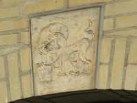 840587 Afbeelding van een sluitsteen met het oud-christelijk symbool van een leeuw, boven een boogvormige ingang aan de ...